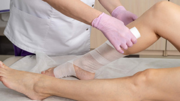 woman's leg being bandaged using lymphedema services