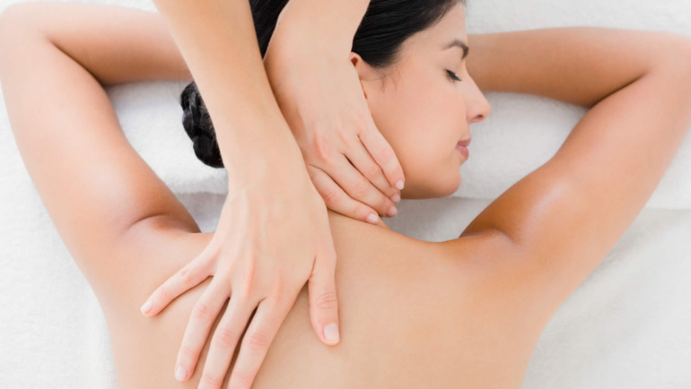 brunette woman receiving a neck massage through massage therapy