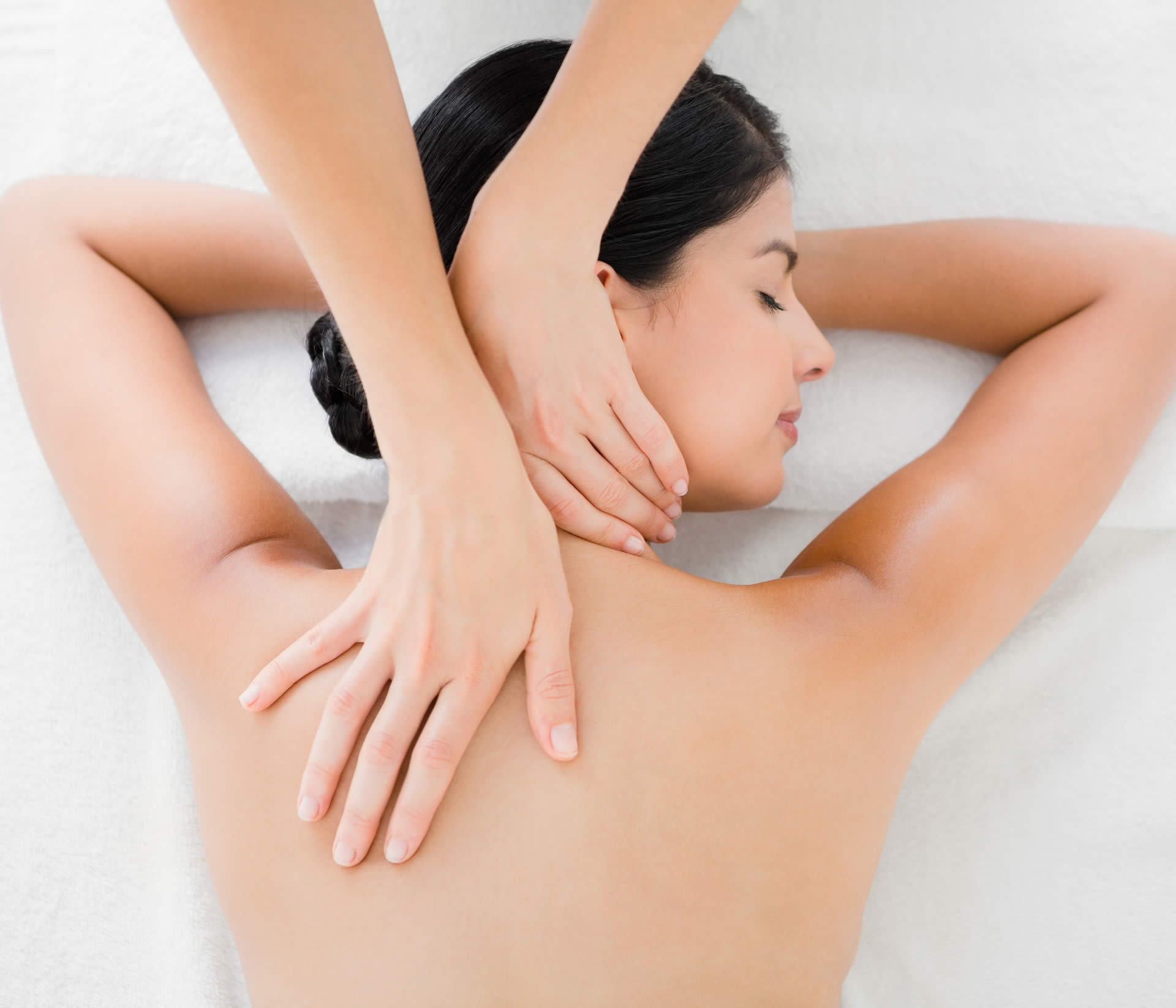 brunette woman receiving a neck massage through massage therapy