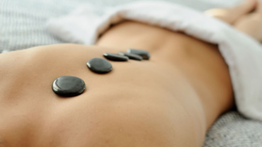 woman using hot stone massage therapy